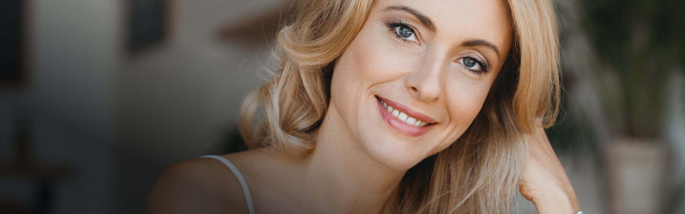 Smiling woman with blonde hair and blue eyes.