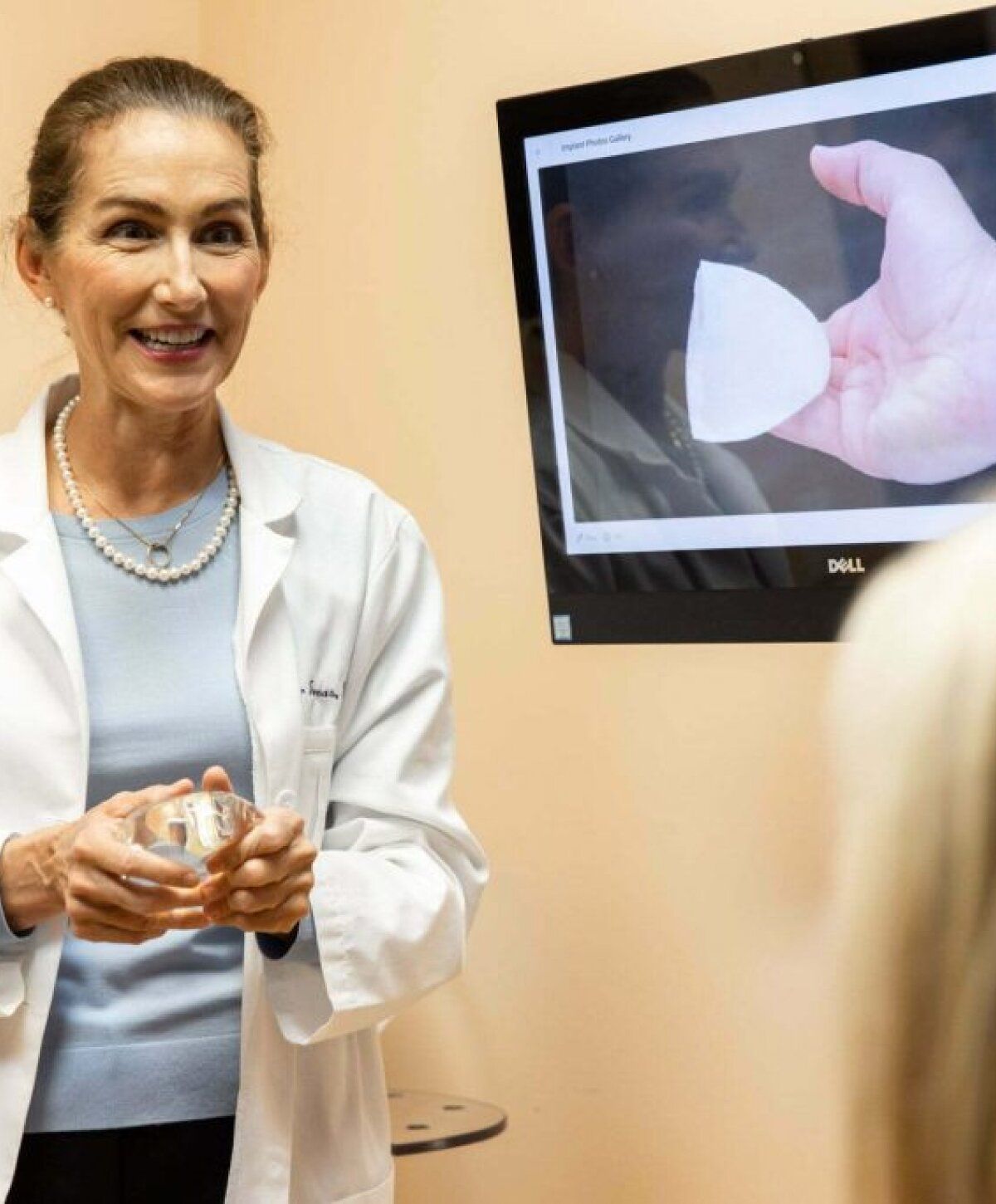 Doctor explaining procedure with implant demonstration.