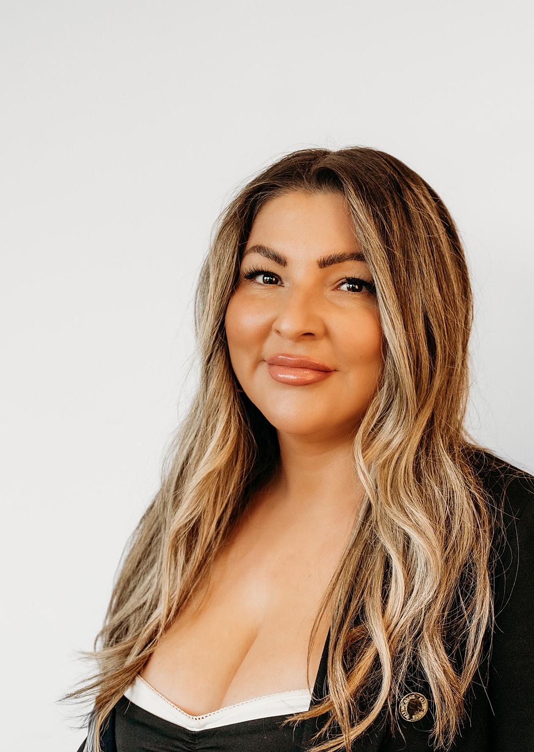 Smiling woman with long brown hair, black jacket.