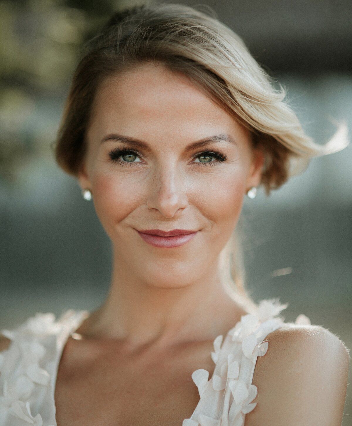 Smiling woman with light-colored hair and makeup.