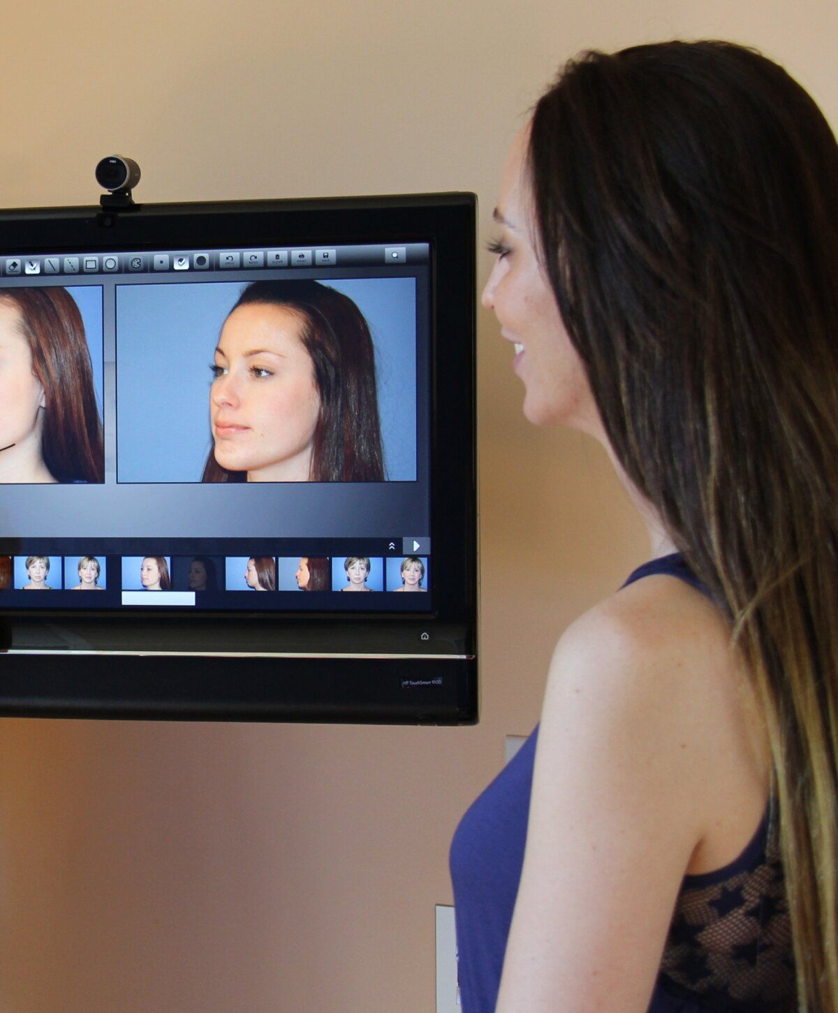 Person viewing digital profile images on screen.
