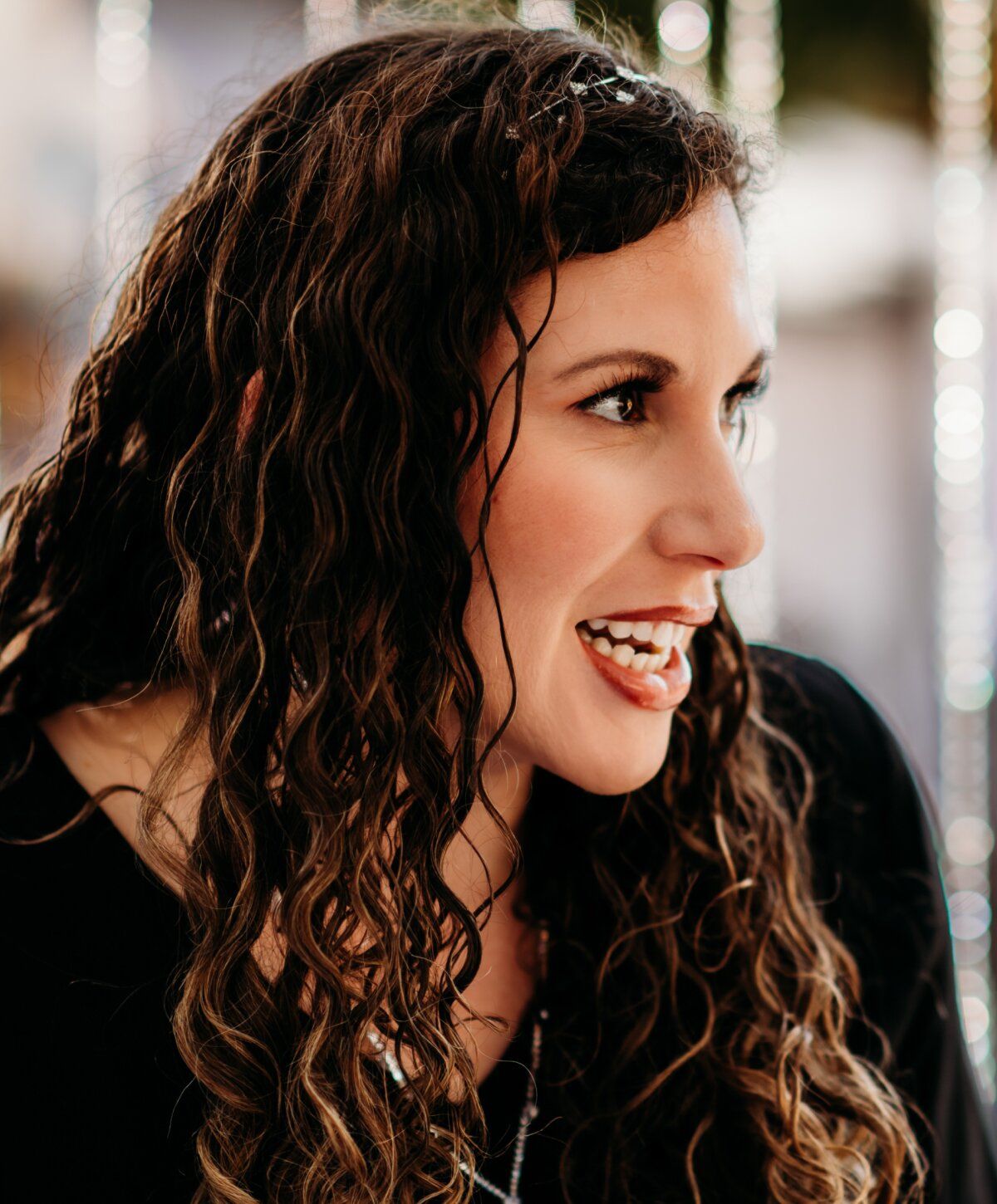 Smiling woman with curly hair in profile.