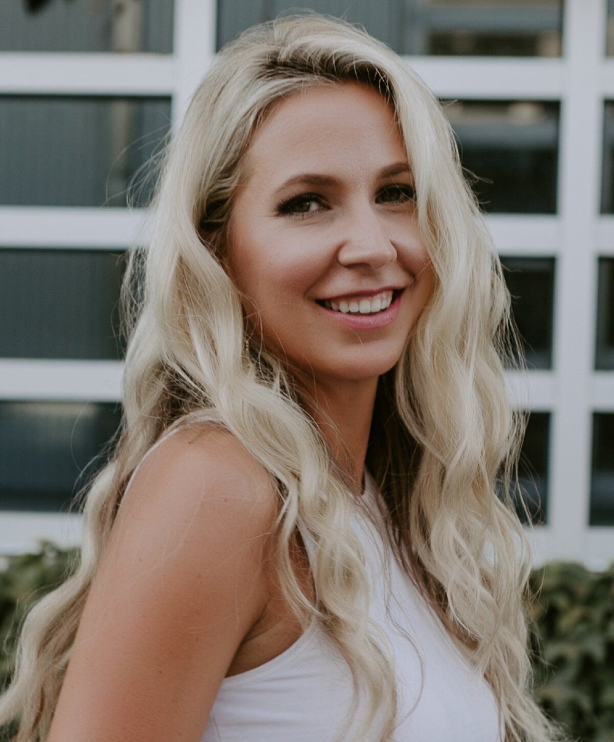 Smiling woman with long, wavy blonde hair.