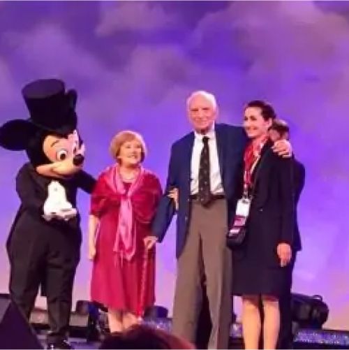 Group photo with Mickey Mouse at an event.