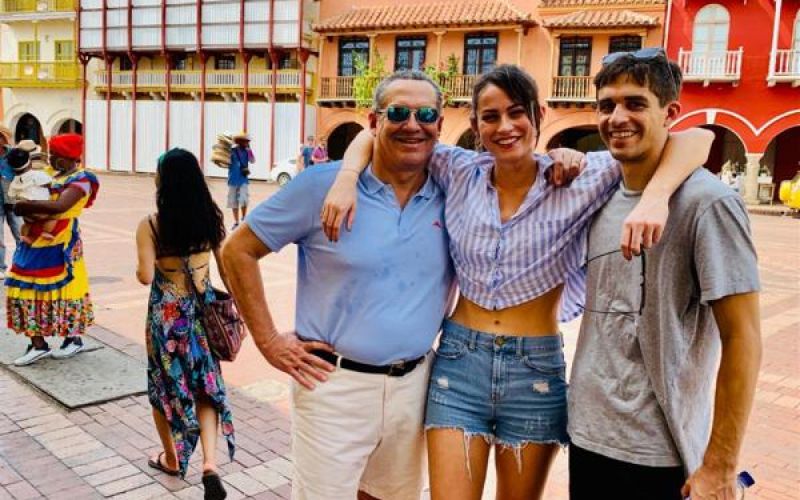 Friends posing happily in vibrant plaza.