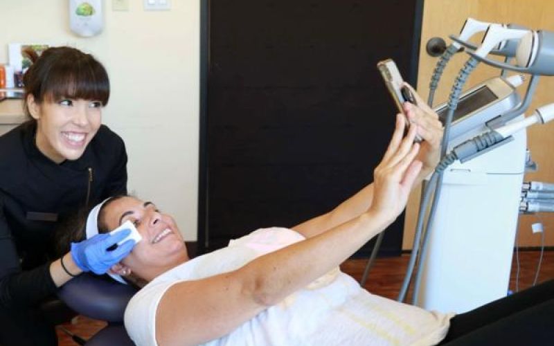 Woman receiving treatment while taking a selfie.