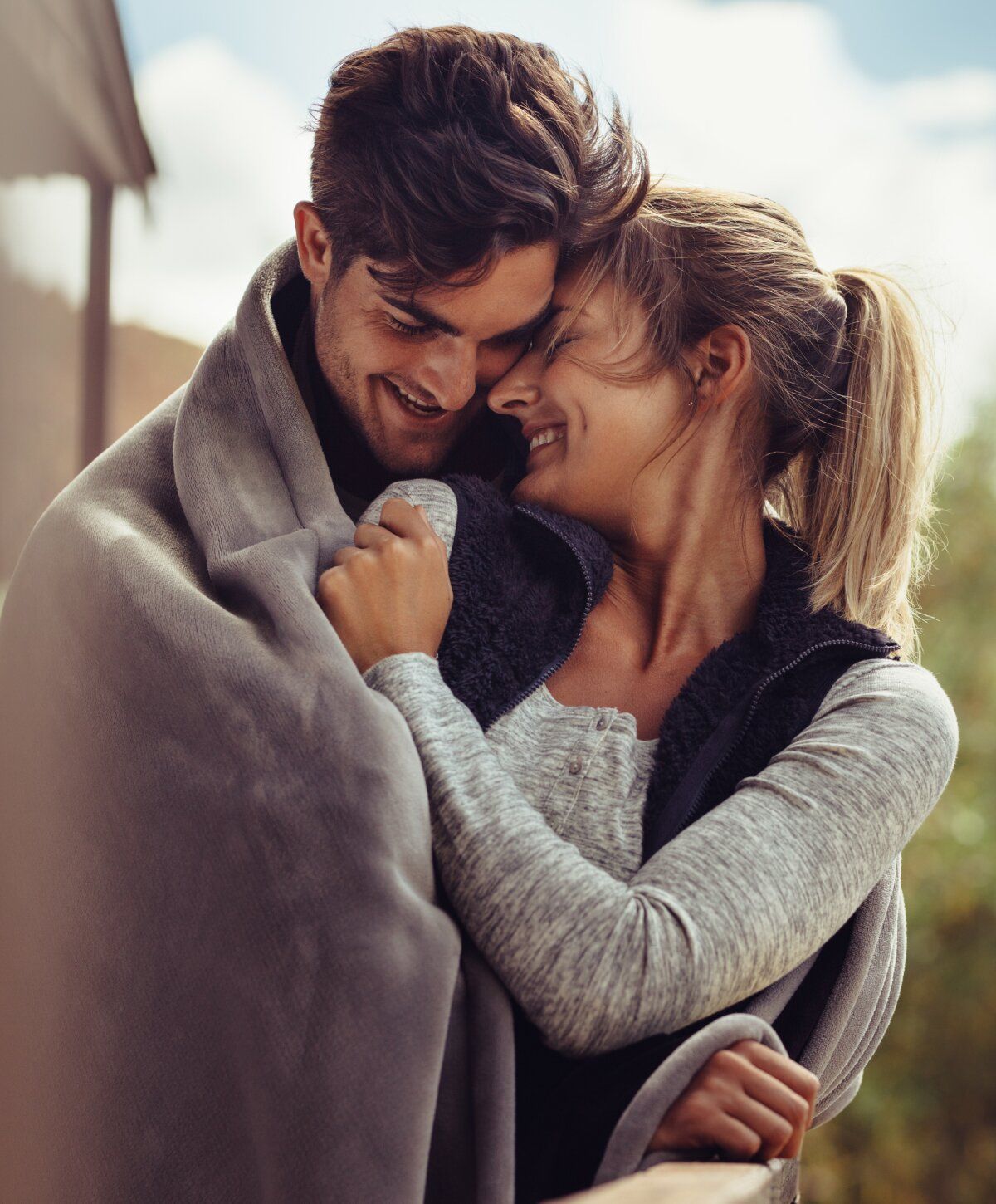 Couple sharing a cozy moment under a blanket.