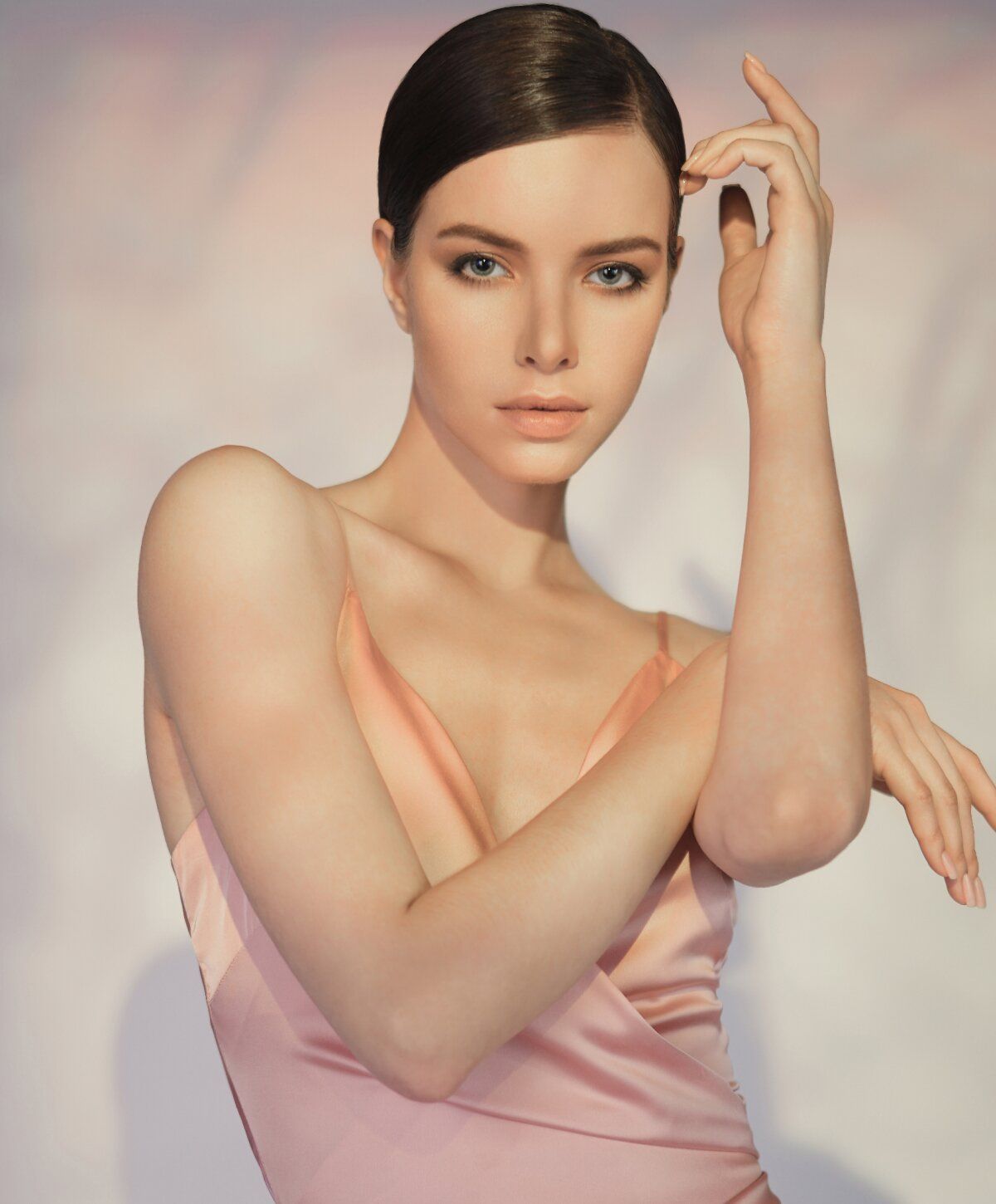 Model posing elegantly in soft pink dress.