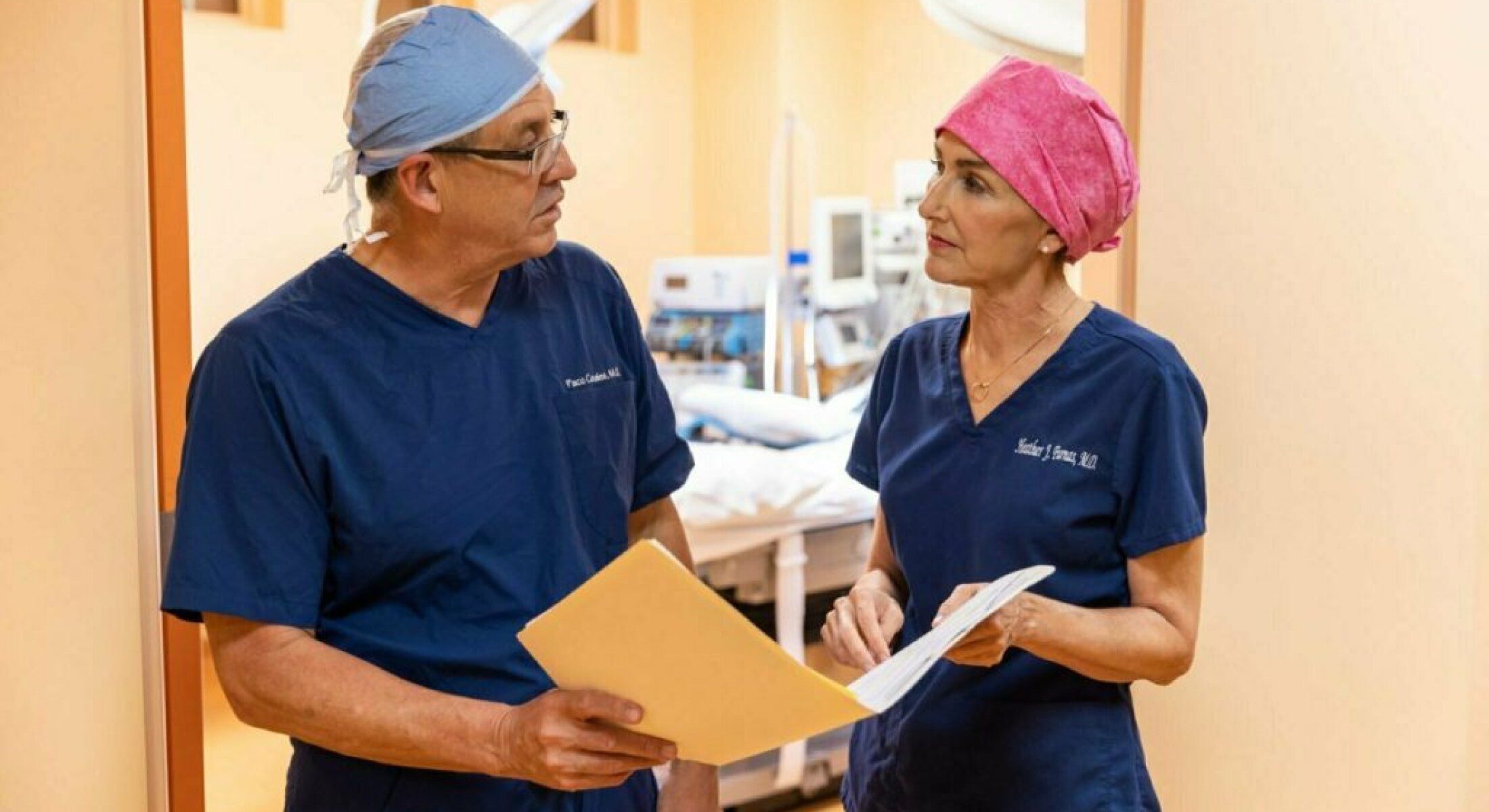 Two doctors discussing patient care in hallway.