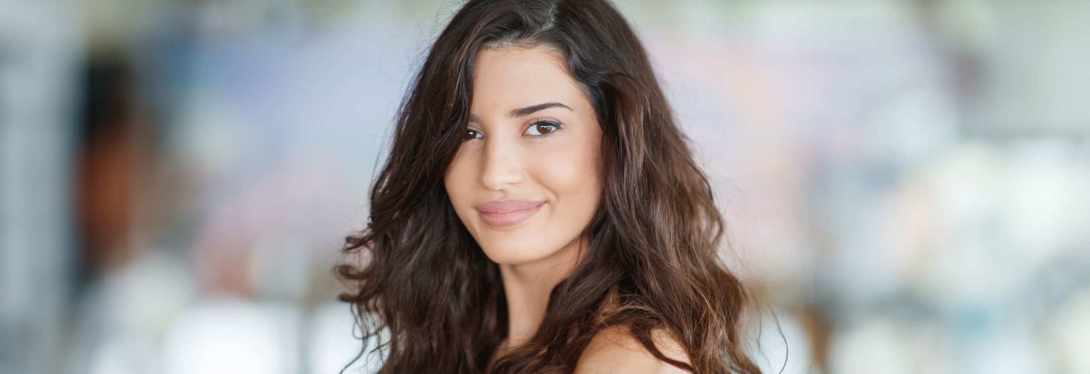Smiling woman with long, wavy hair.