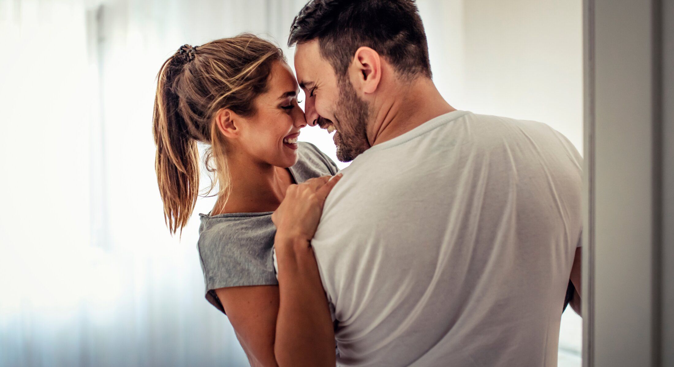 Couple sharing an intimate moment, smiling together.