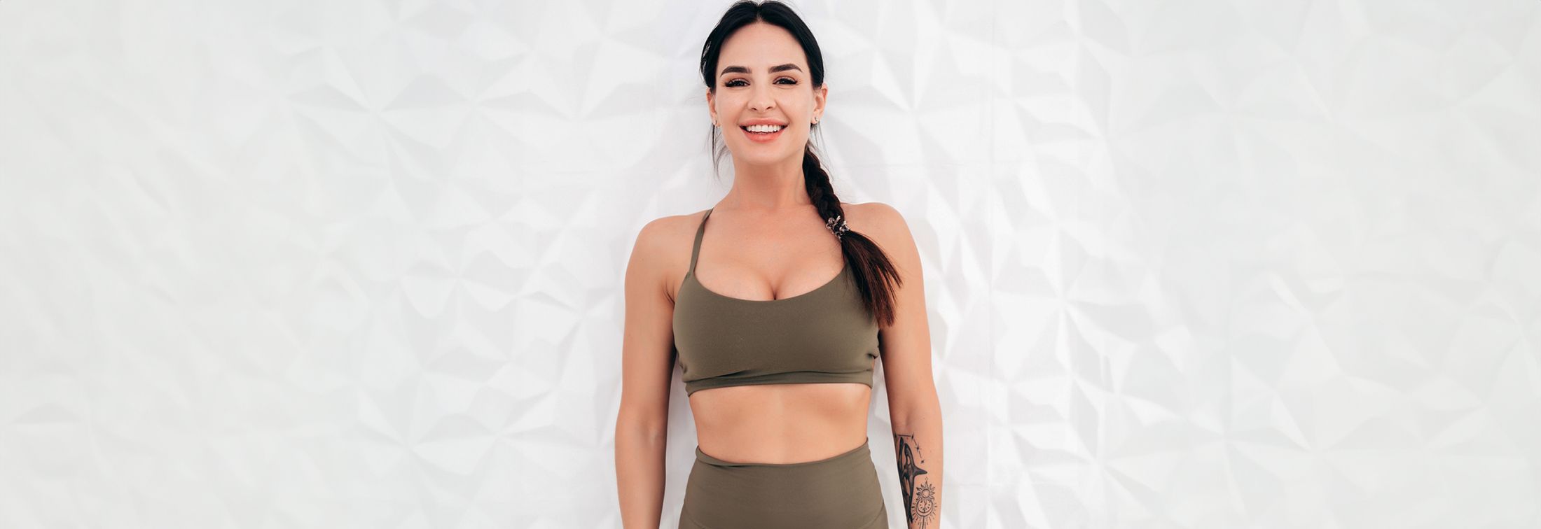 Smiling person in athletic wear against white background.